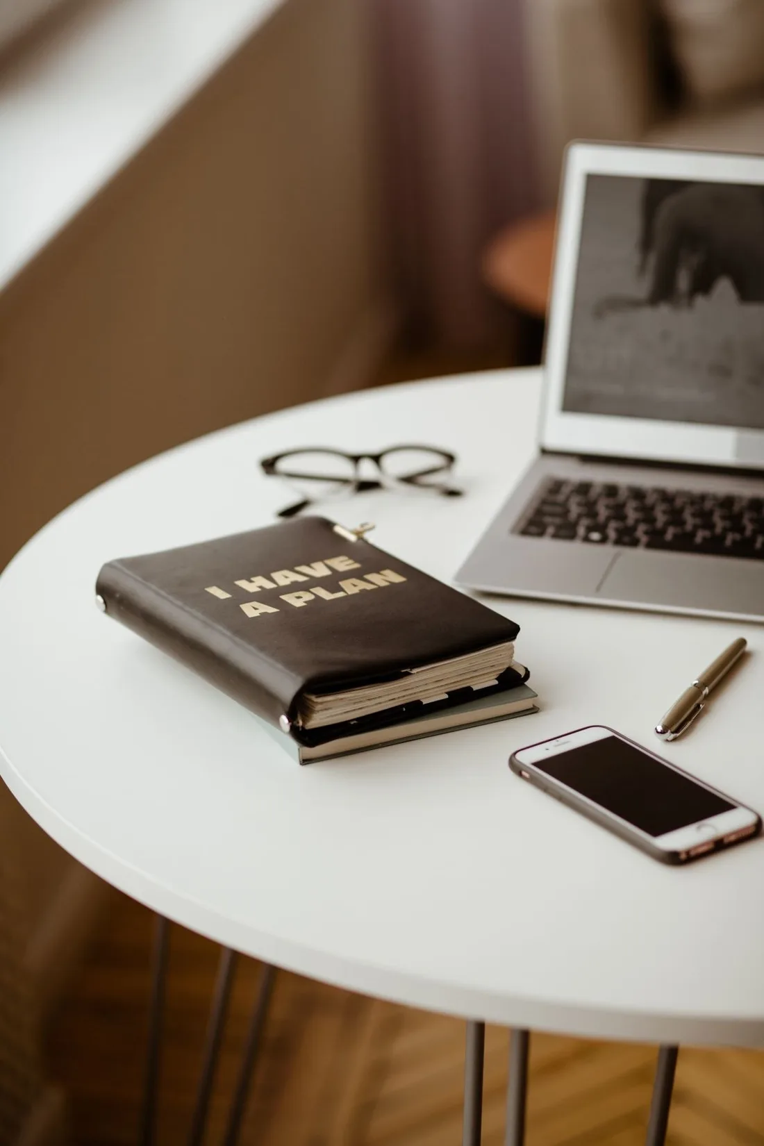 Buku perencanaan di samping laptop
